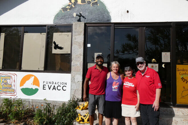 Four Zoo volunteers standing outside of a building, smiling for the camera.